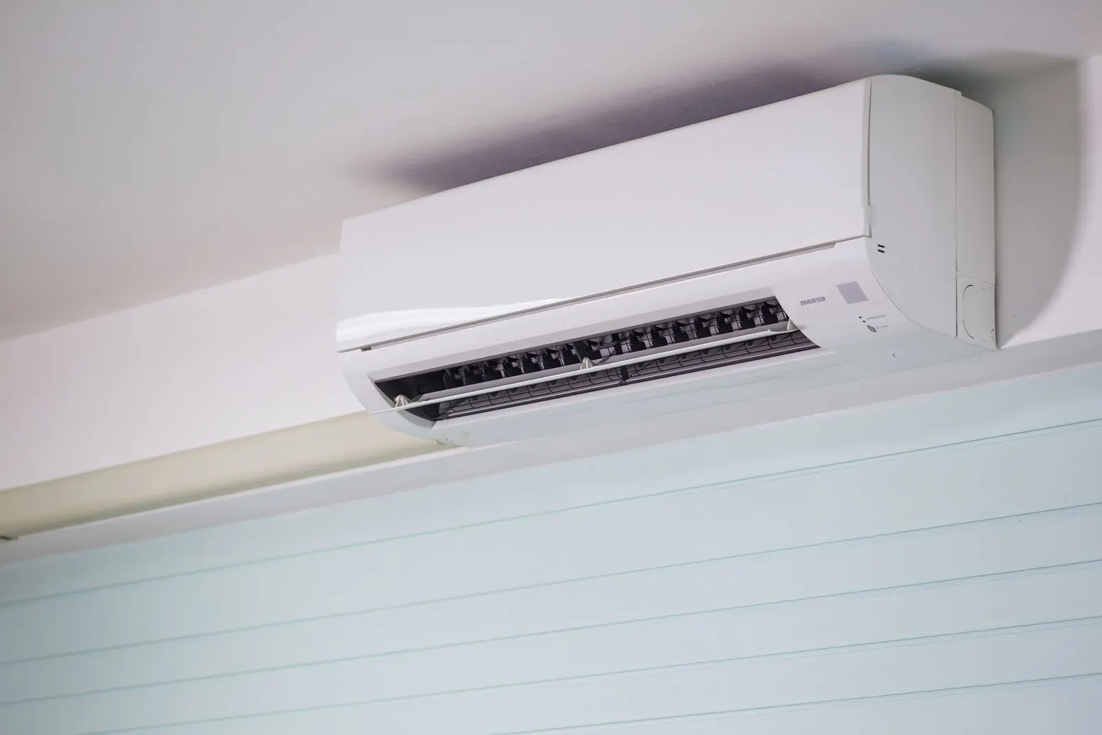Ductless mini-split head mounted high on a white wall