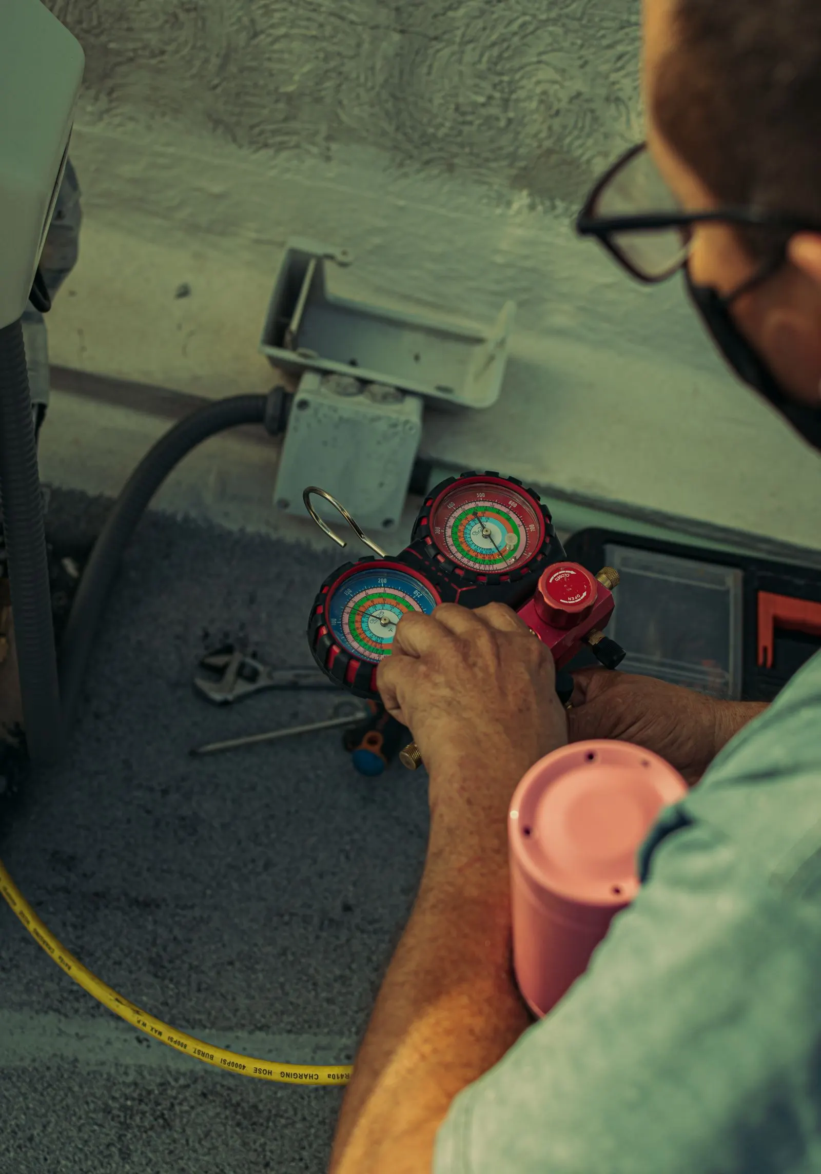 Technician reading refrigerant manifold gauges