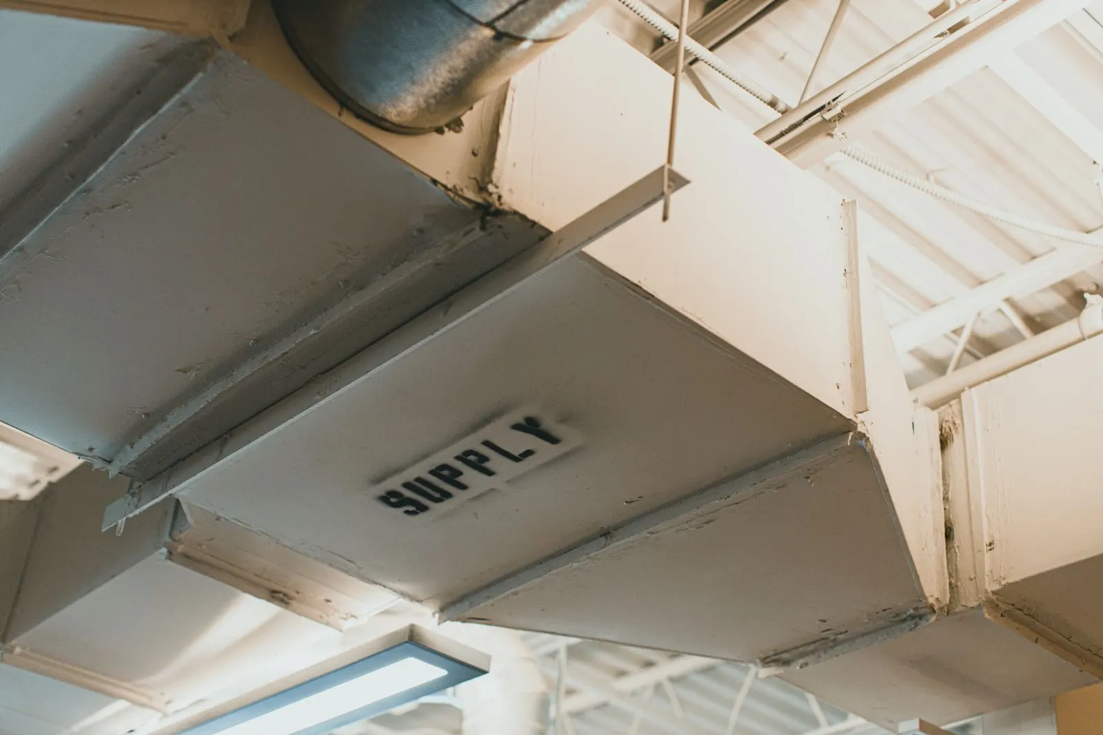 Sheet-metal supply air ductwork under a ceiling